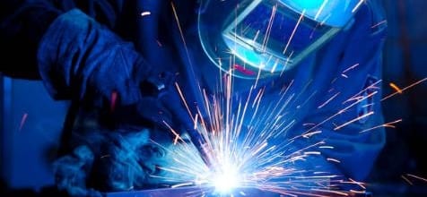 Welder with helmet and sparks flying